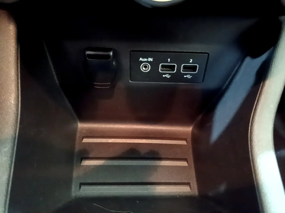 Prise auxiliaire et deux ports USB dans le rangement central d'une Renault Clio Business blanche de 2021.