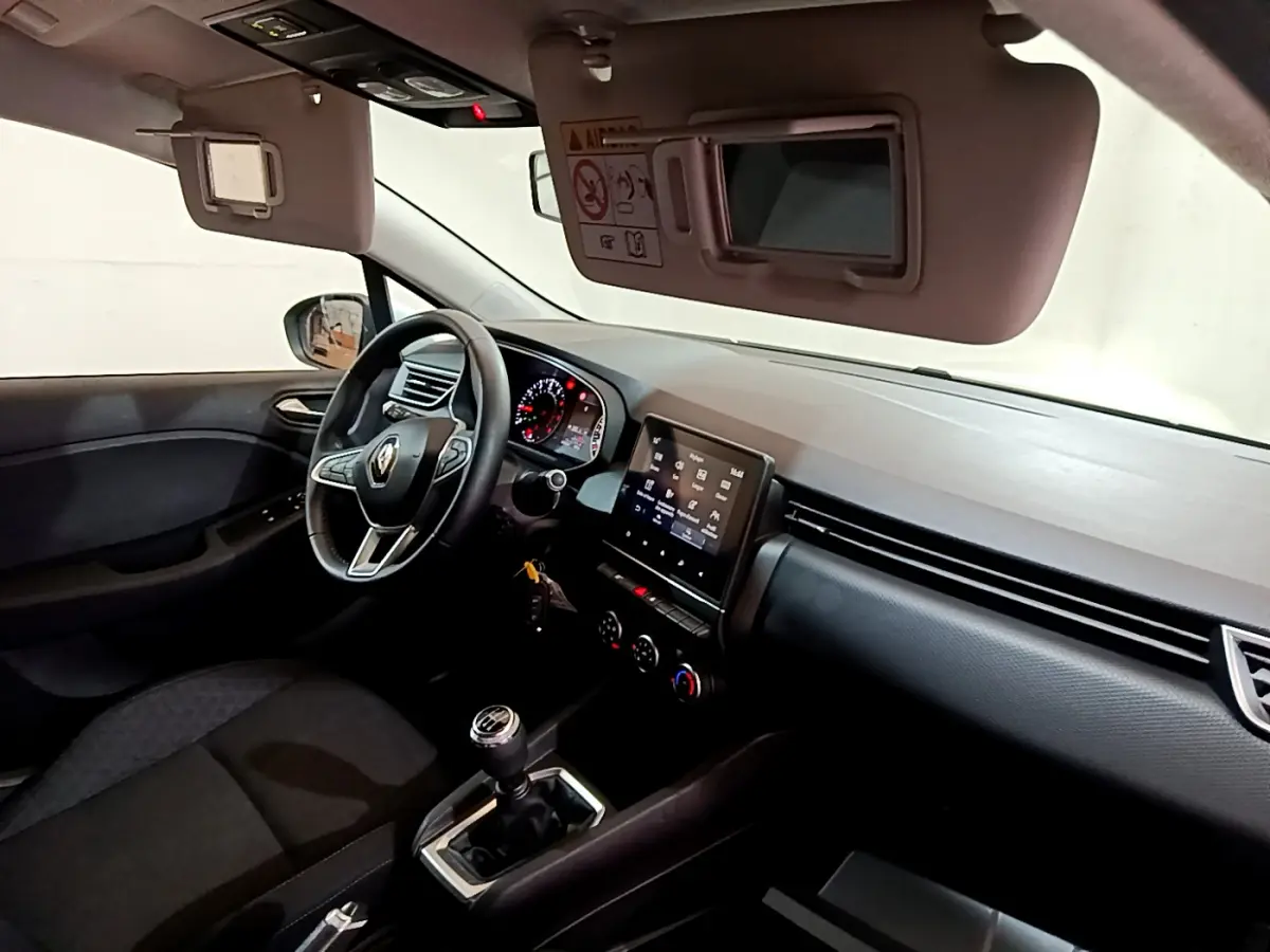 Intérieur noir de la Renault Clio Business 2021 vu côté conducteur, volant cuir et écran tactile central visible.