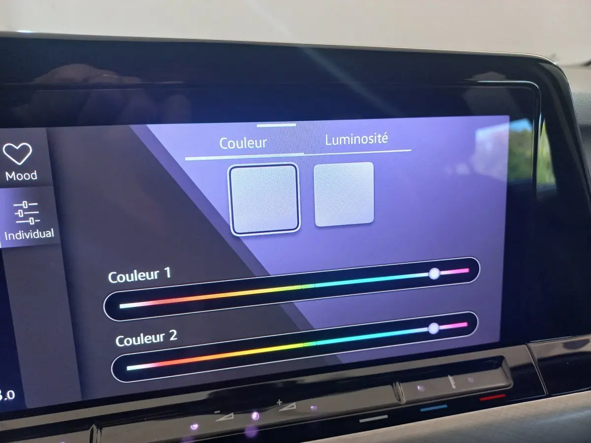 Écran tactile du tableau de bord de la Volkswagen Golf 2022 affichant réglages couleur et luminosité de l'ambiance lumineuse