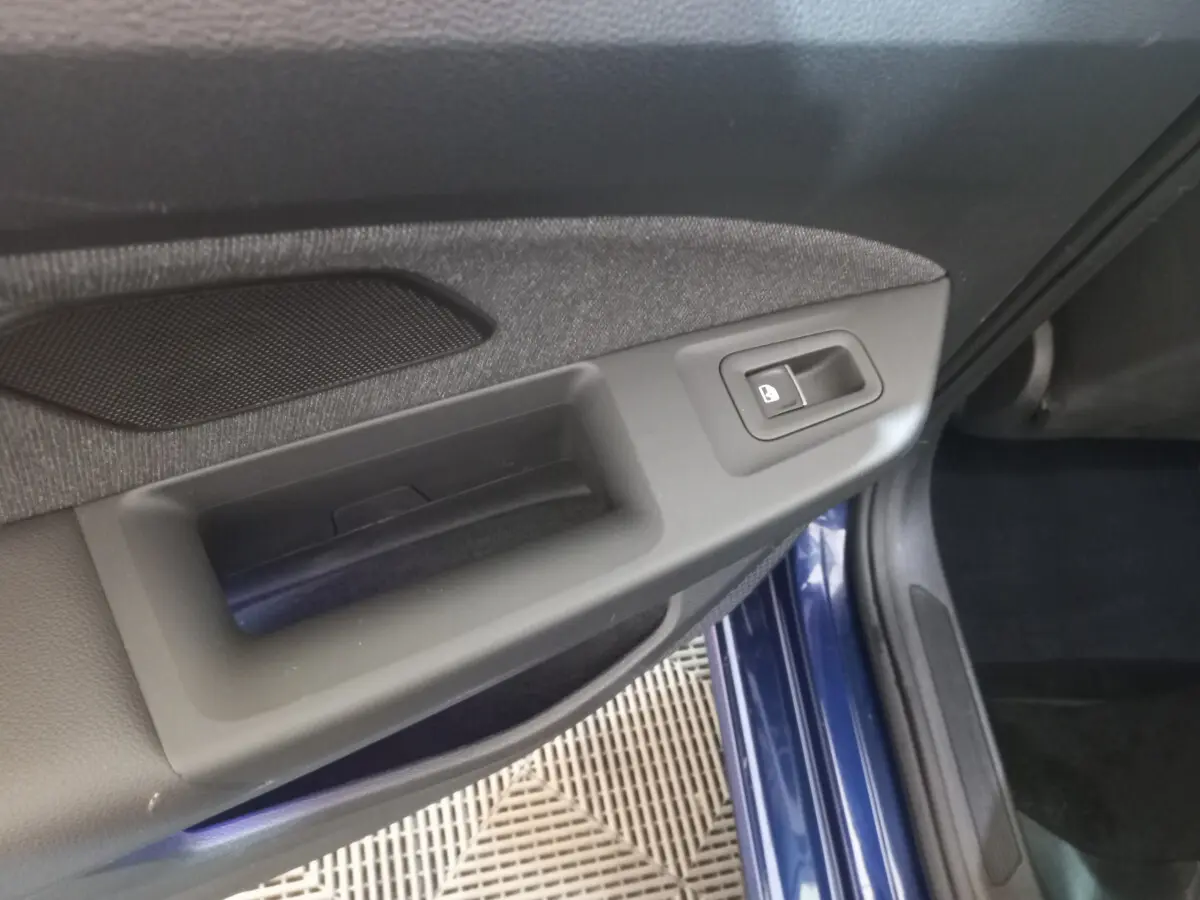 Détail de la poignée intérieure côté gauche avec bouton de verrouillage sur une Volkswagen Golf bleu 2022.