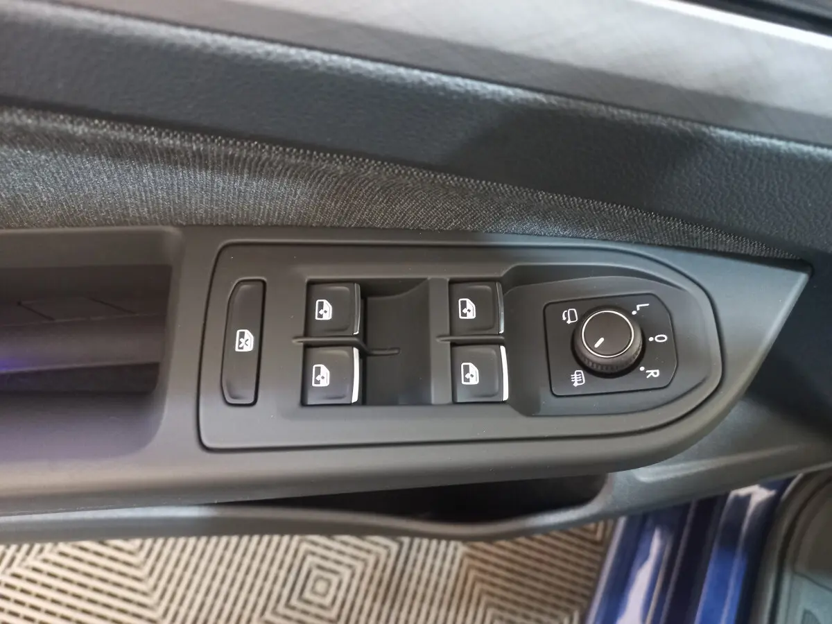 Vue rapprochée des commandes de lève-vitres et réglage des rétroviseurs côté conducteur d'une Volkswagen Golf bleu 2022
