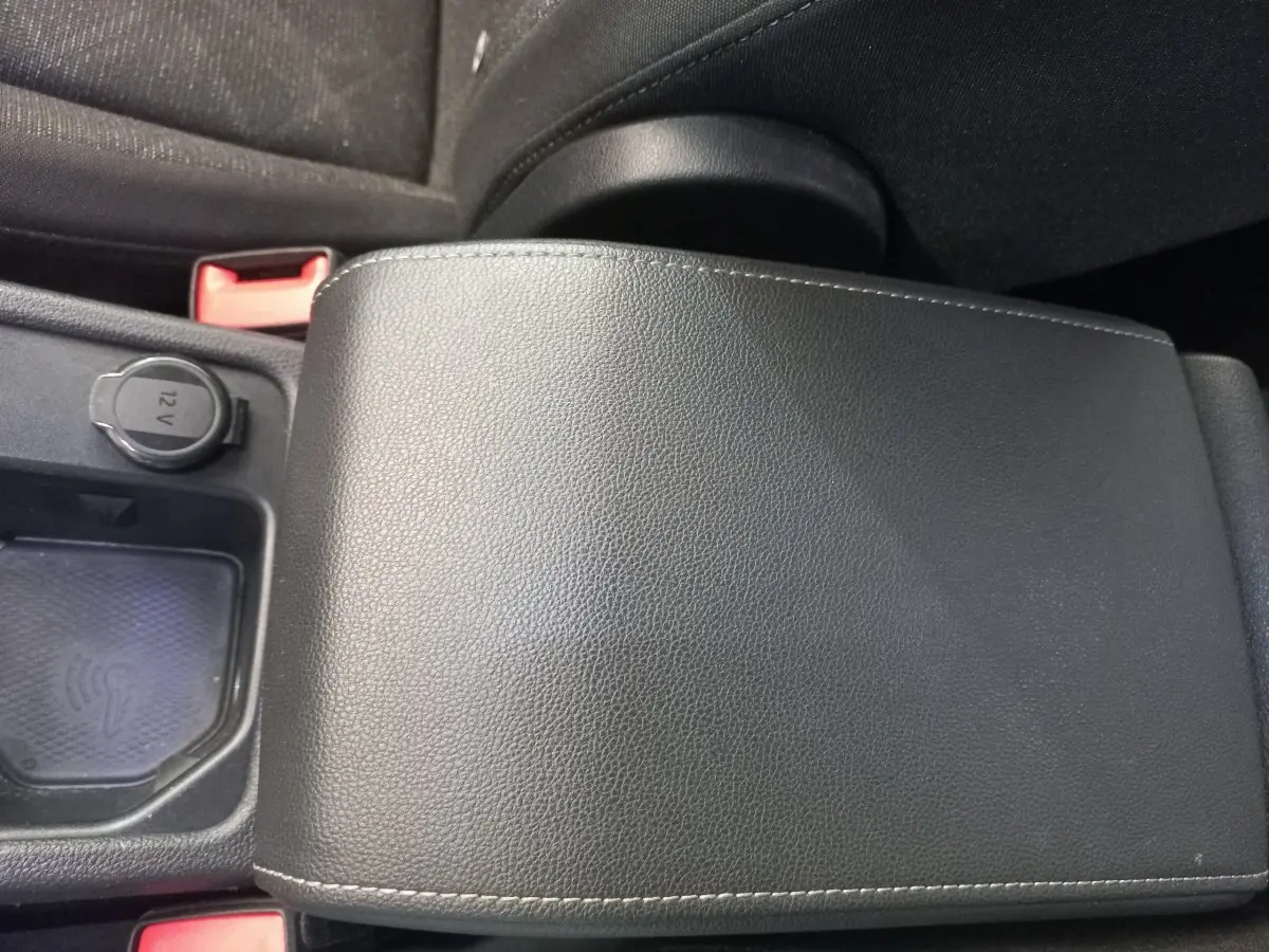 Gros plan sur l'accoudoir central en cuir noir et prise 12V dans l'habitacle d'une Volkswagen Golf 2022.