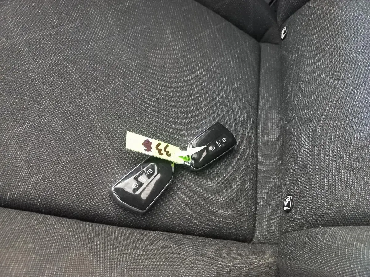 Clé de voiture Volkswagen Golf 2022 posée sur la banquette arrière en tissu gris foncé avec logo ISOFIX visible.
