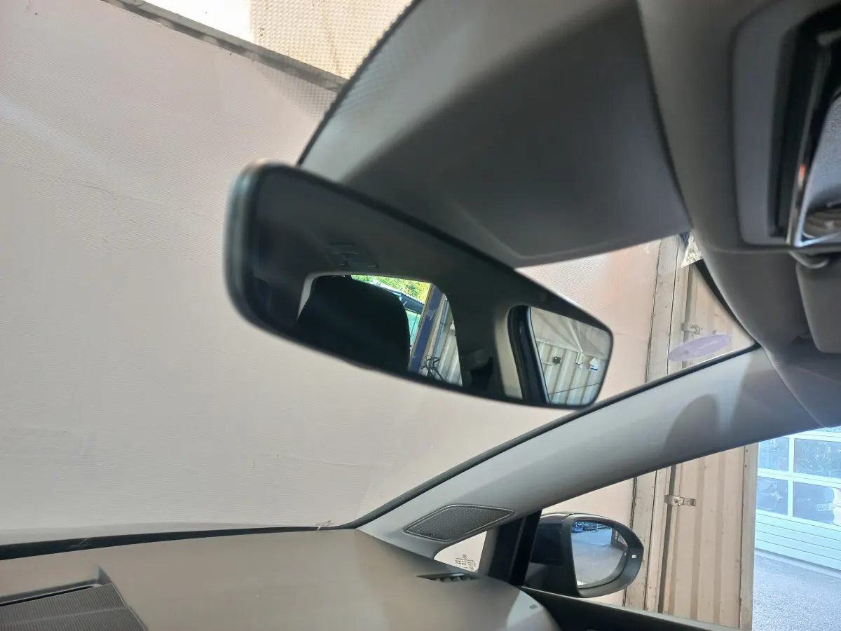 Vue intérieure côté gauche du rétroviseur intérieur et extérieur d'une Volkswagen Golf bleu 2022 stationnée en garage.