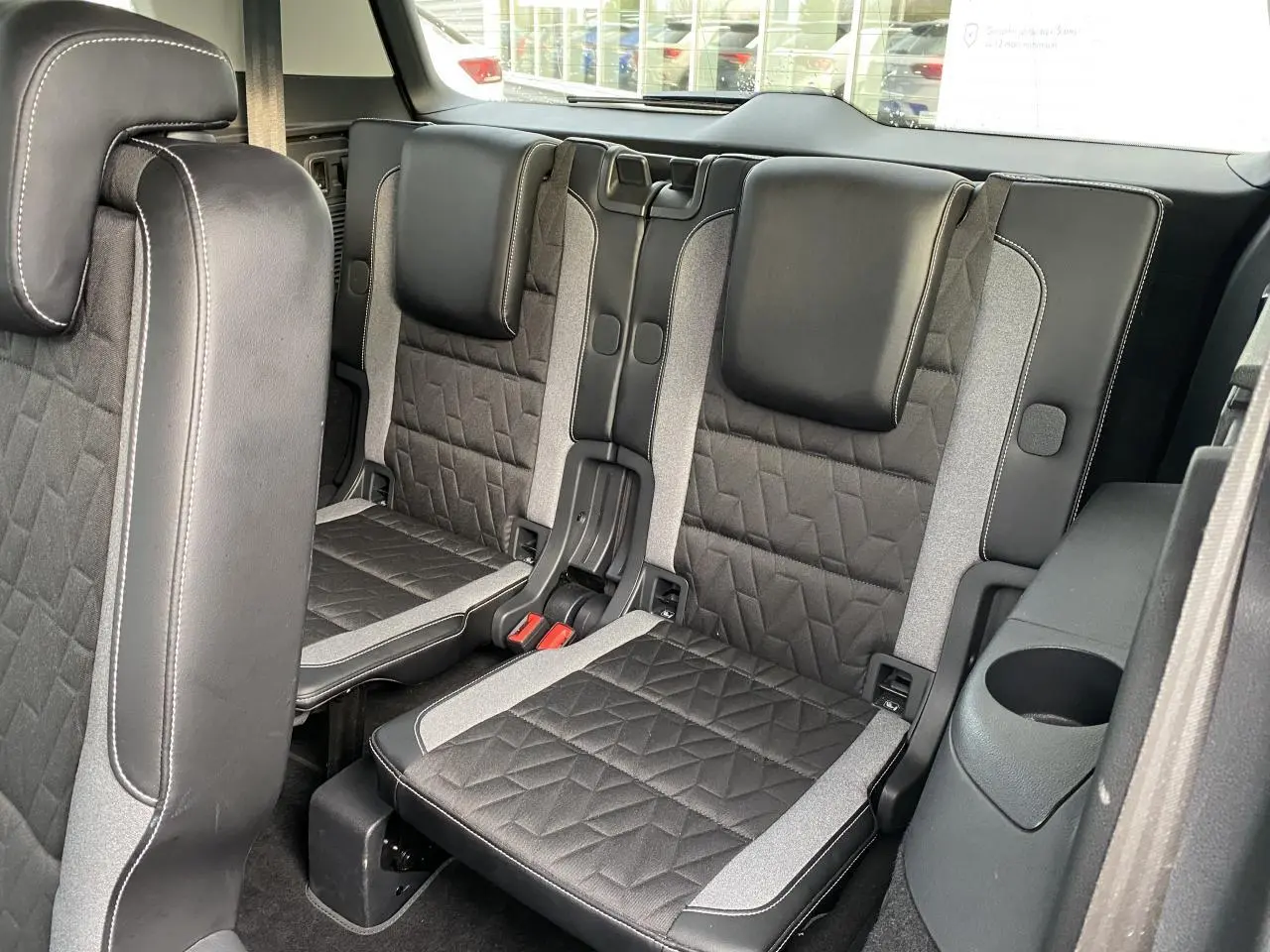 Vue intérieure sur les sièges arrière en cuir noir et tissu gris du Volkswagen Touran 2025, version 7 places.