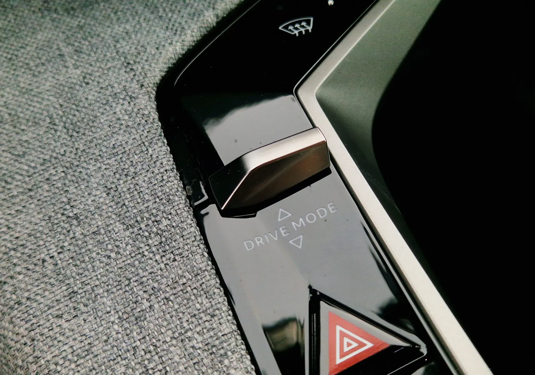 Gros plan sur le bouton Drive Mode et le bouton de warning triangulaire dans l’habitacle du Peugeot 3008 gris Artense.