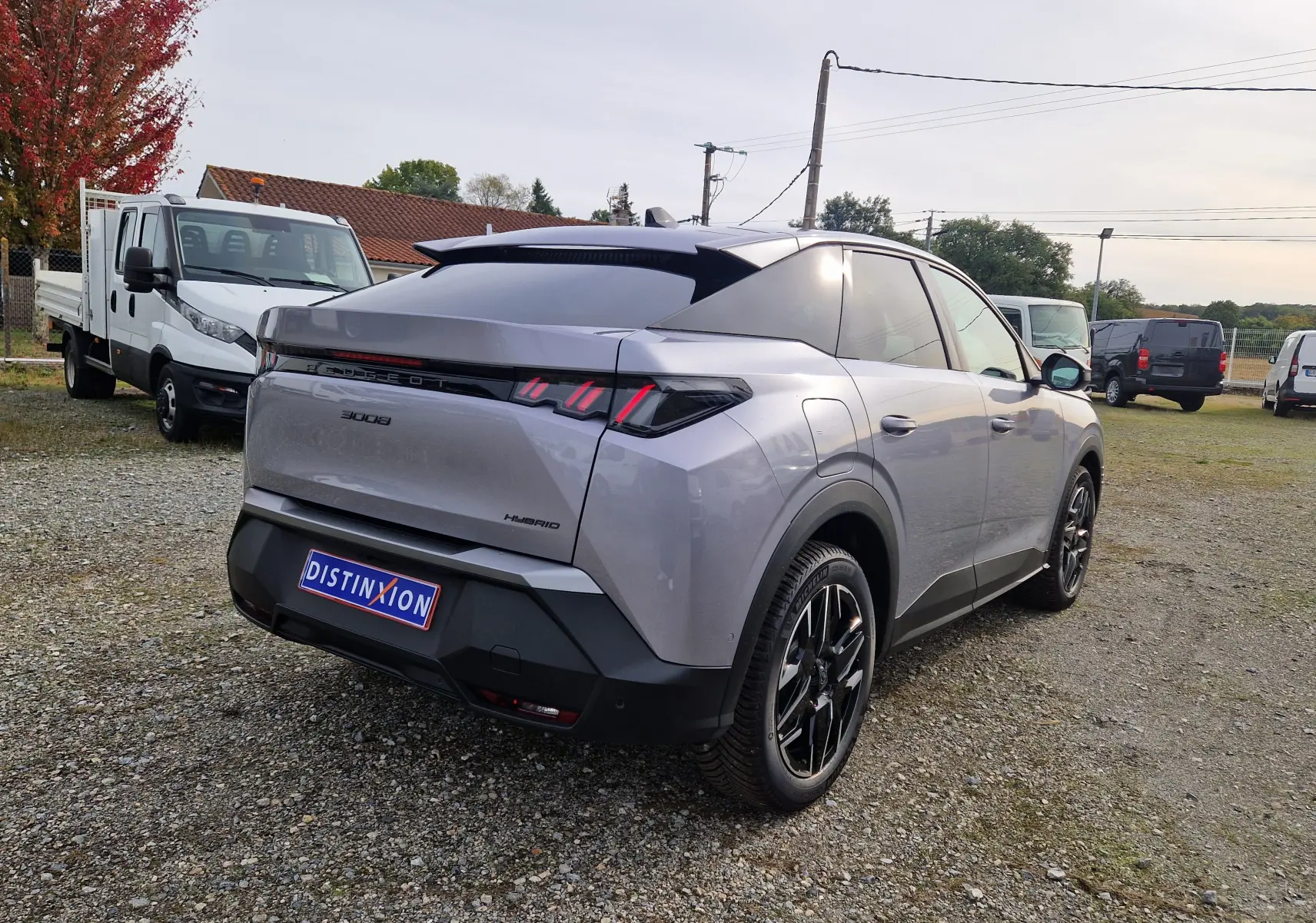 Vue 3/4 arrière droite d'un Peugeot 3008 gris Artense 2025 avec feux arrière LED distinctifs et jantes noires.