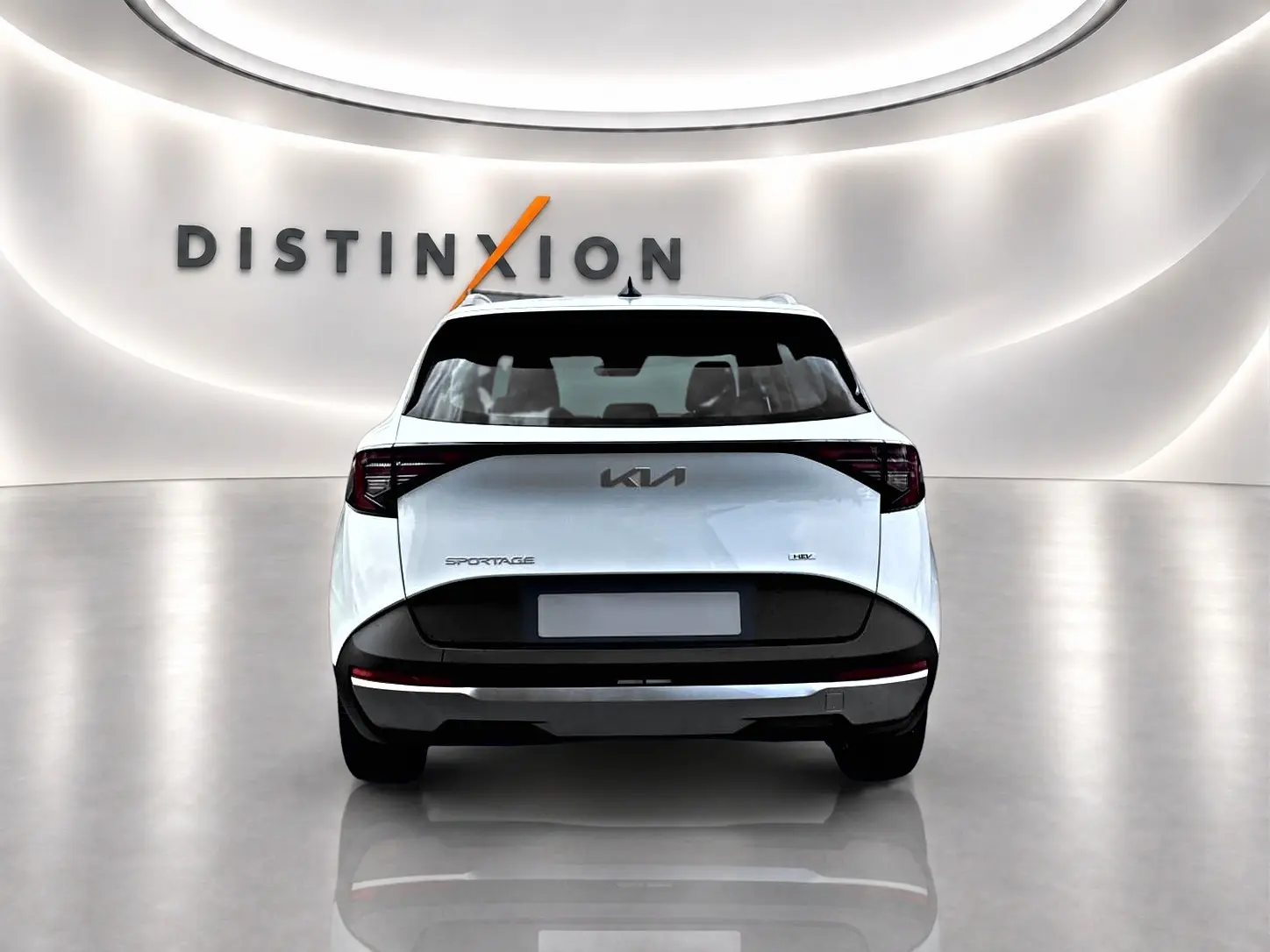 Vue arrière d’un KIA Sportage blanc 2026 avec feux arrière LED et logo central dans un showroom lumineux.