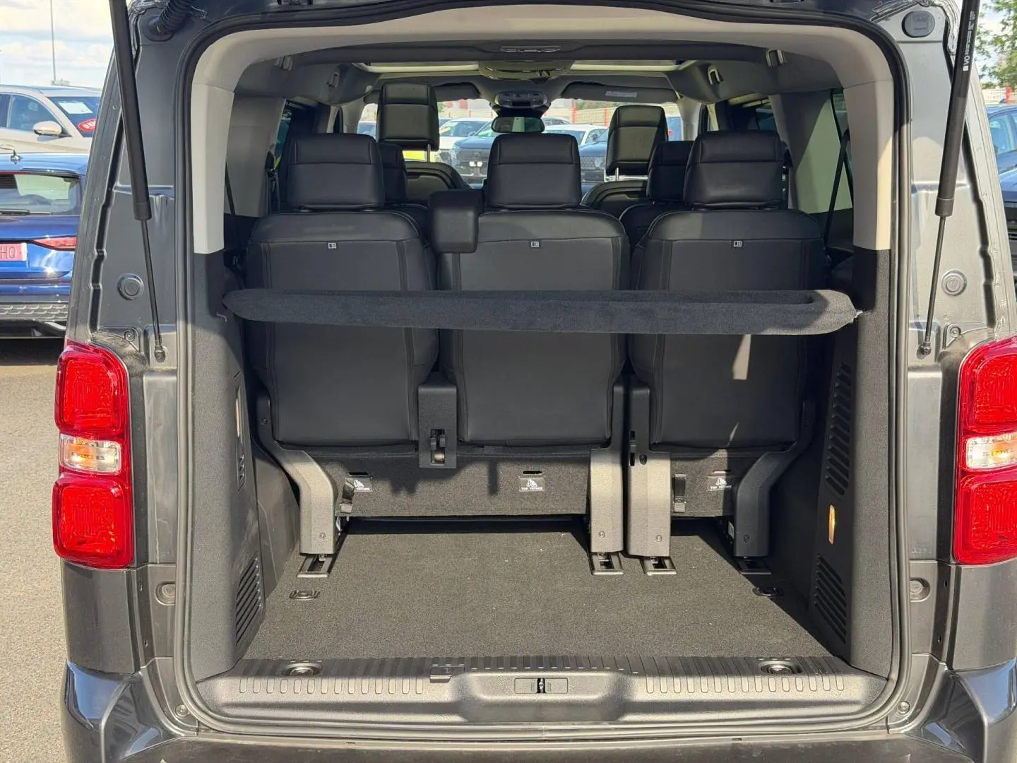 Vue arrière ouverte du Citroën Spacetourer XL gris titane montrant le coffre et la troisième rangée de sièges en tissu bi-ton noir/gris.