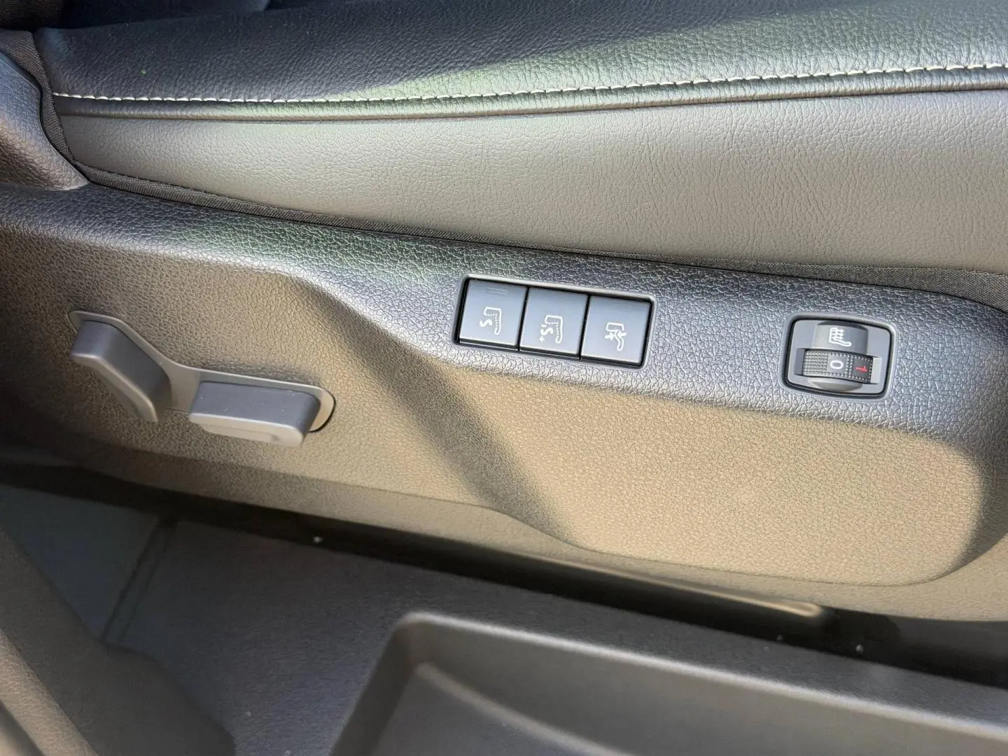 Gros plan sur les commandes de réglage électrique et chauffant du siège conducteur en tissu bi-ton gris du Citroën Spacetourer XL.