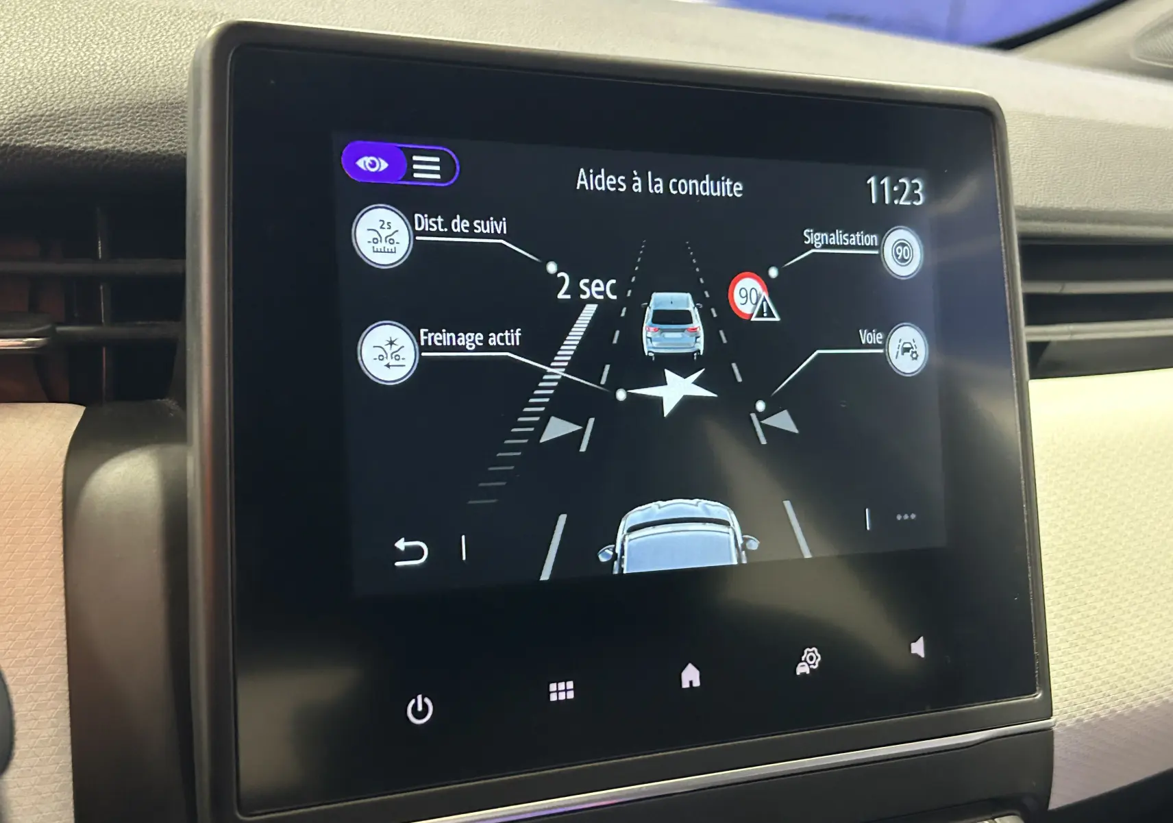 Écran central de la Renault Clio V TCe 90 gris montrant l'aide à la conduite avec caméra 360° et alertes de sécurité.