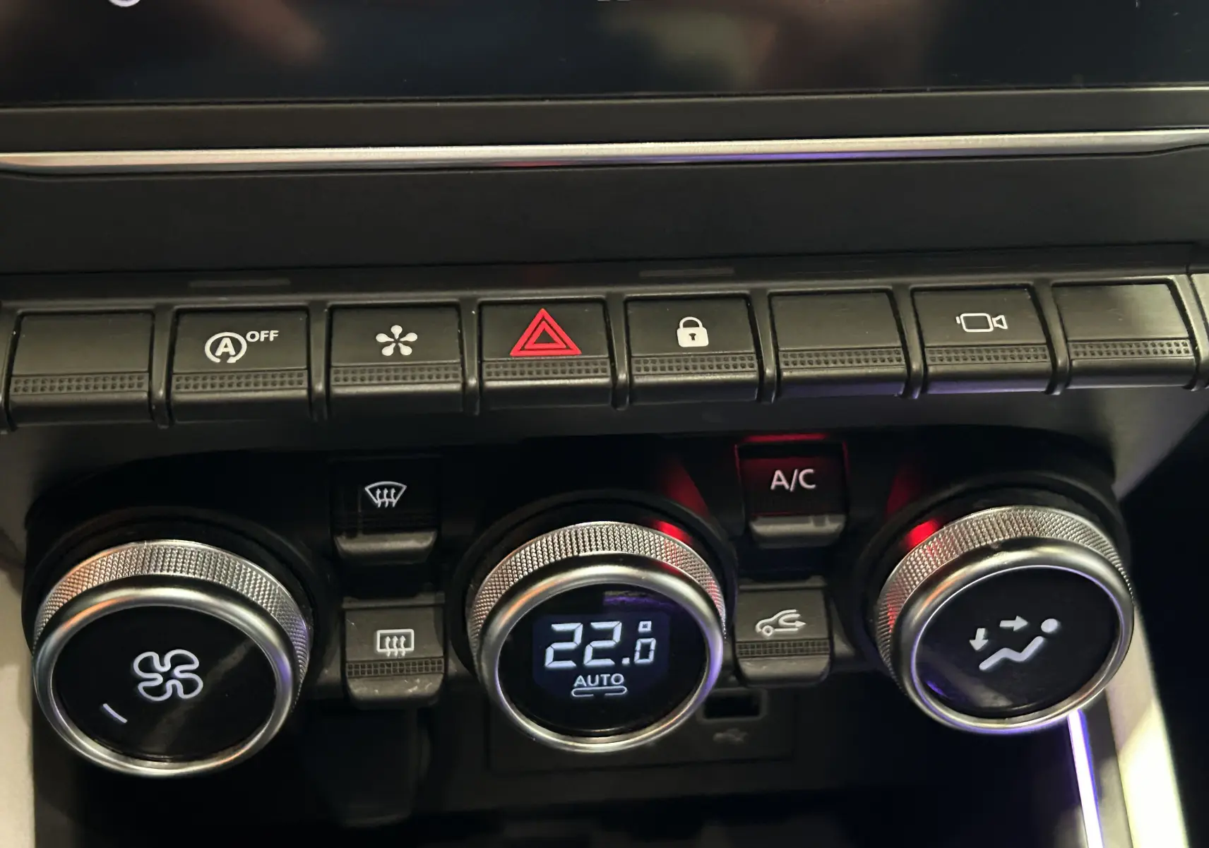 Gros plan sur la console centrale de la Renault Clio V TCe 90 TECHNO 2023, montrant les commandes de climatisation digitales.