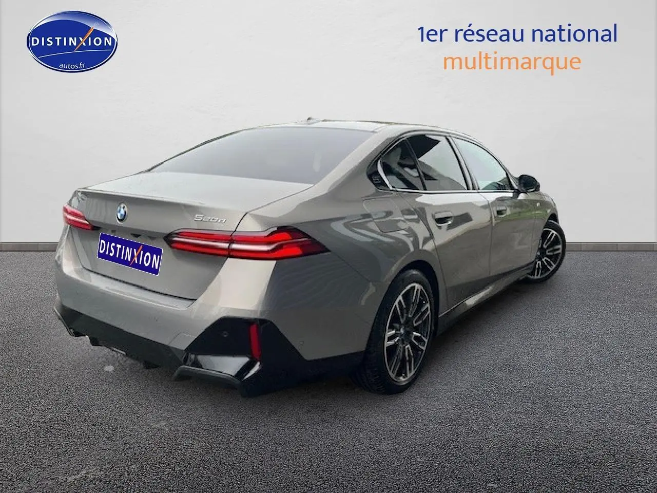 BMW Série 5 520da gris vue 3/4 arrière droit, jantes alliage et feux arrière LED distinctifs.