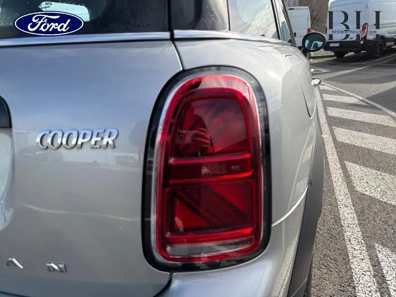 Gros plan sur le feu arrière droit rouge et l’inscription Cooper d’une MINI Countryman Melting Silver III vue de l’arrière.