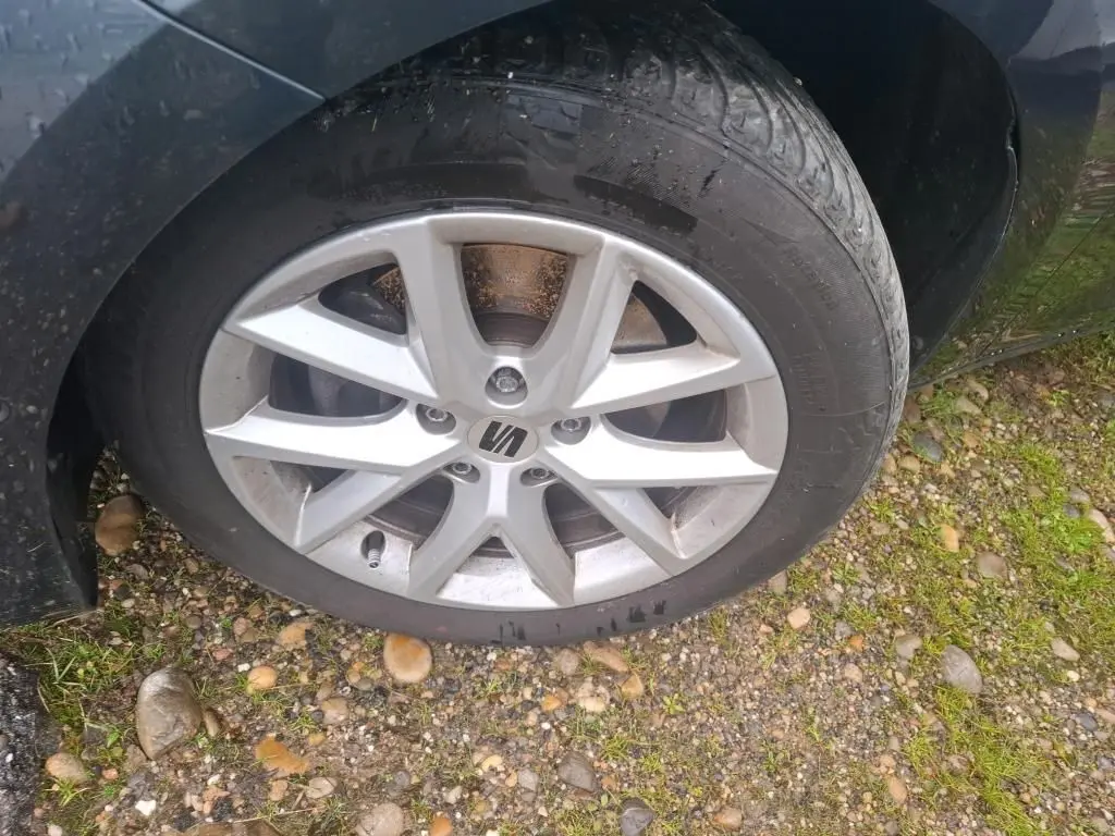 Gros plan sur la roue avant droite d'une SEAT Leon gris 2021 avec jante alliage et logo central visible.
