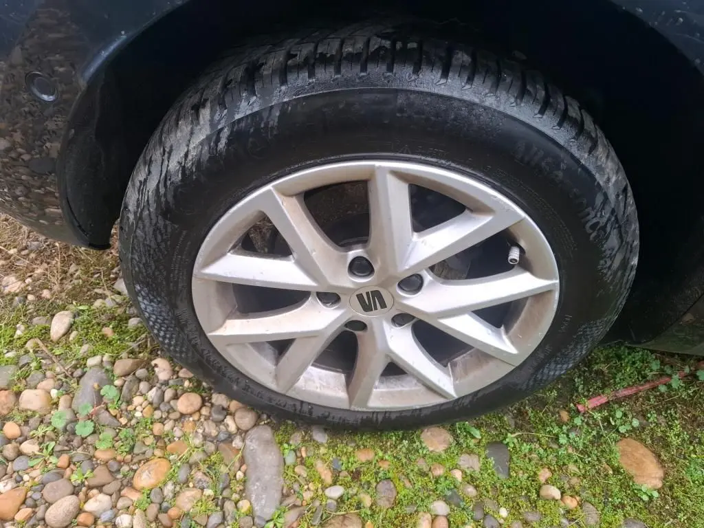 Gros plan sur la roue avant gauche d'une SEAT LEON gris 2021, avec jante alliage à cinq branches doubles.