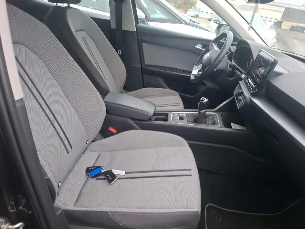 Vue intérieure côté conducteur du SEAT Leon 2.0 TDI 115 STYLE 2021, sièges tissu gris avec clés posées dessus.