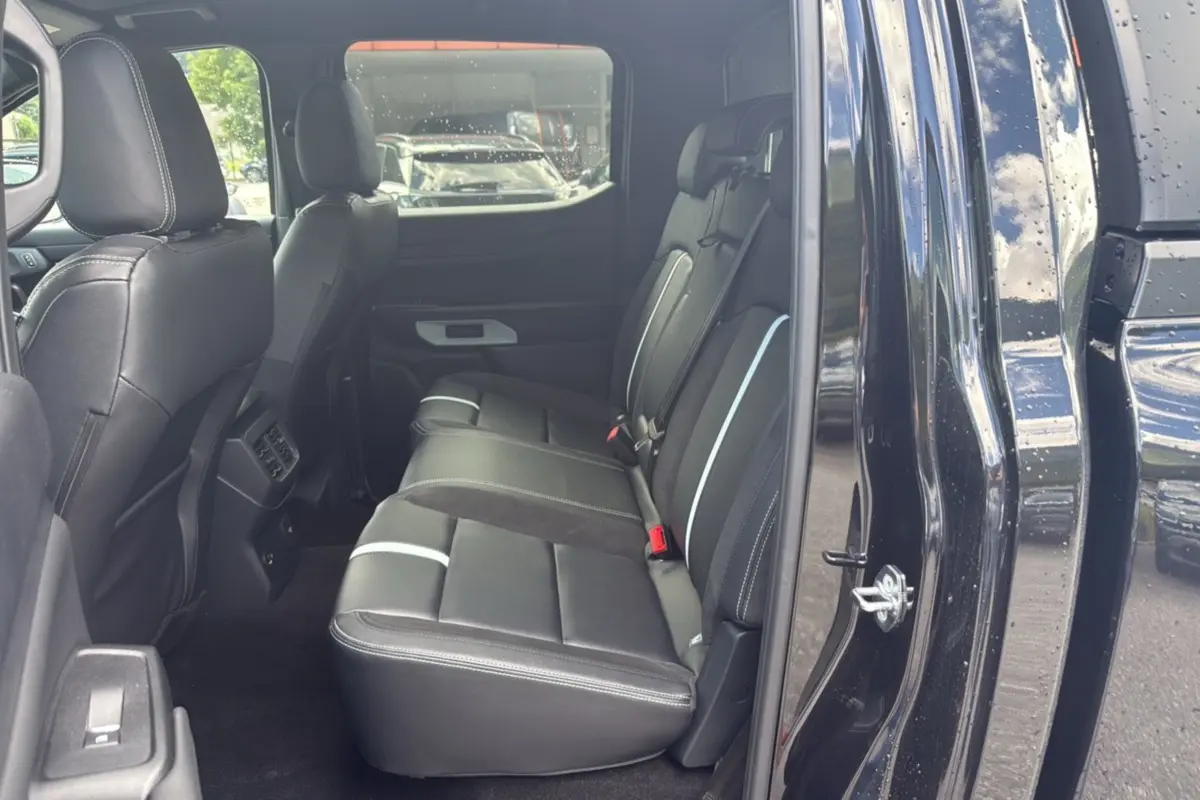 Vue côté gauche des sièges arrière en cuir noir avec surpiqûres blanches du Ford Ranger 2.3 PHEV noir agate.