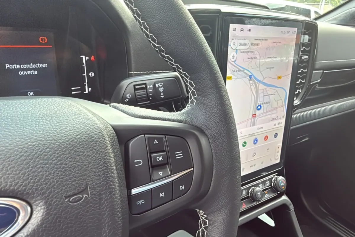 Vue intérieure centrée sur le volant cuir multifonctions et l'écran tactile vertical du Ford Ranger noir agate.