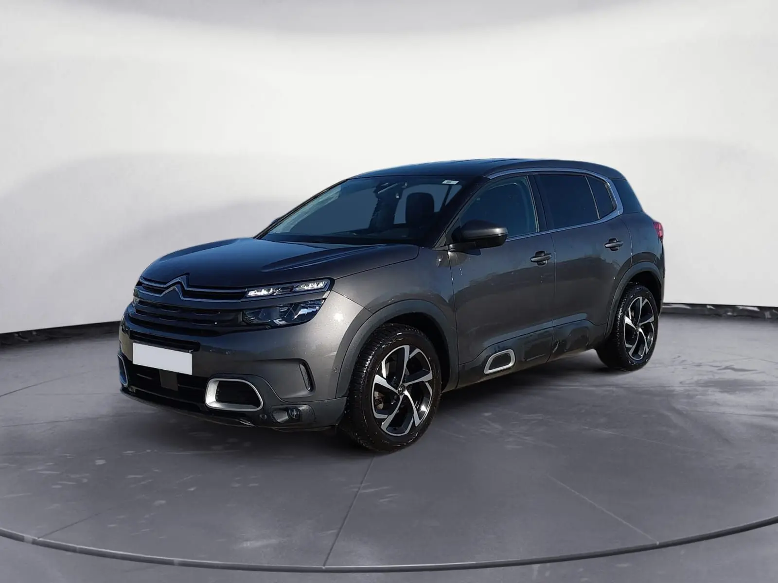 Citroën C5 Aircross gris platinium en 3/4 avant droit, avec jantes bi-ton et détails chromés sur boucliers et bas de caisse.