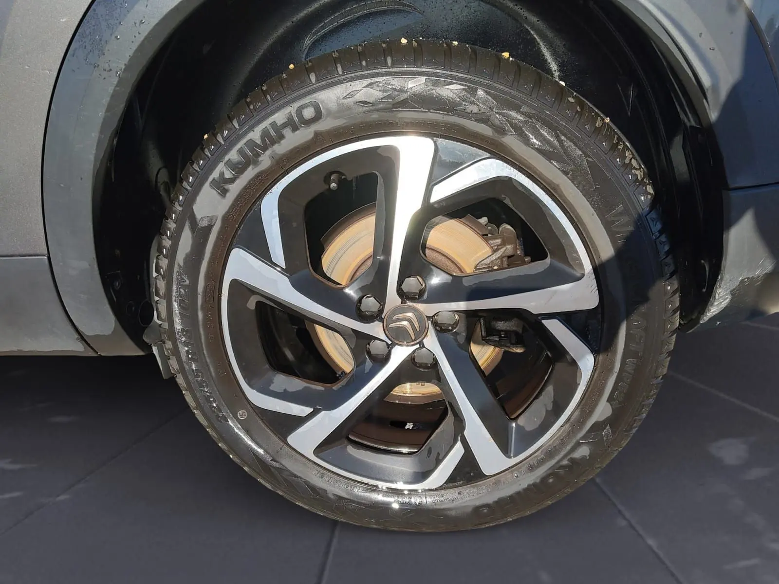 Gros plan sur la roue avant droite du Citroën C5 Aircross gris platinium avec jante alliage bi-ton et pneu Kumho.