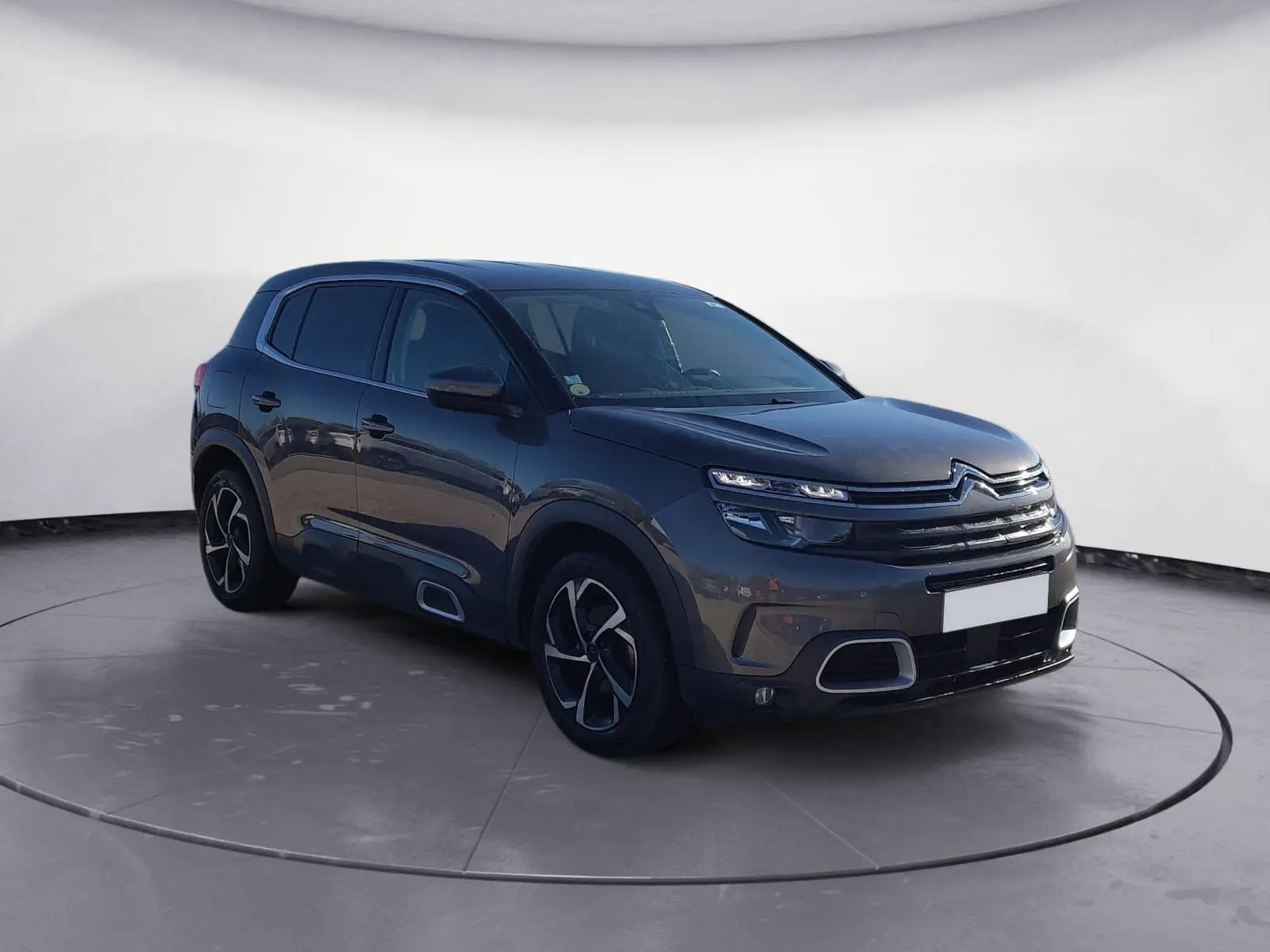Citroën C5 Aircross gris platinium en 3/4 avant droit, avec jantes bi-ton et calandre distinctive.
