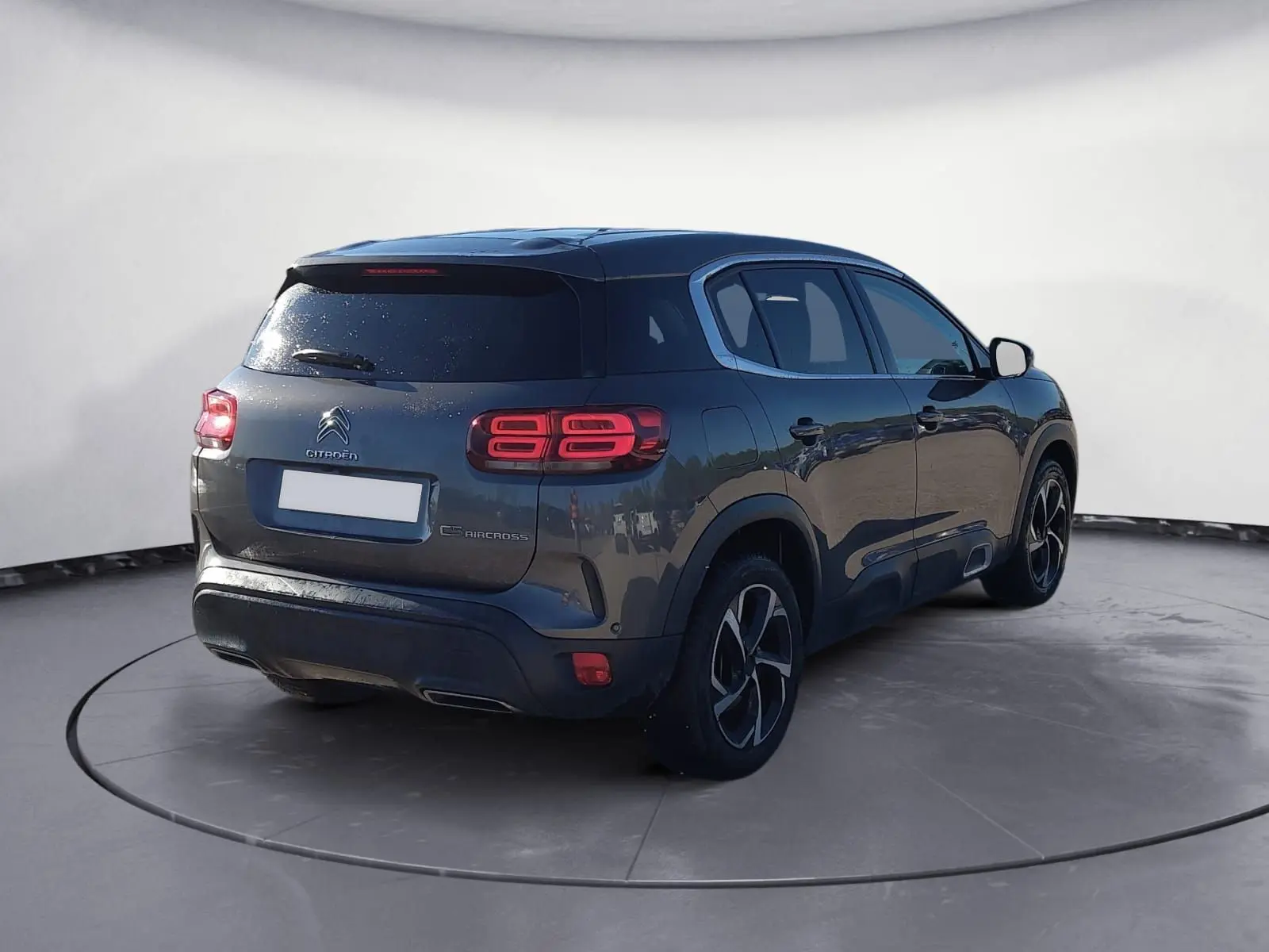 Vue 3/4 arrière droite d'un Citroën C5 Aircross gris platinium avec feux arrière LED et jantes bi-ton 18 pouces.