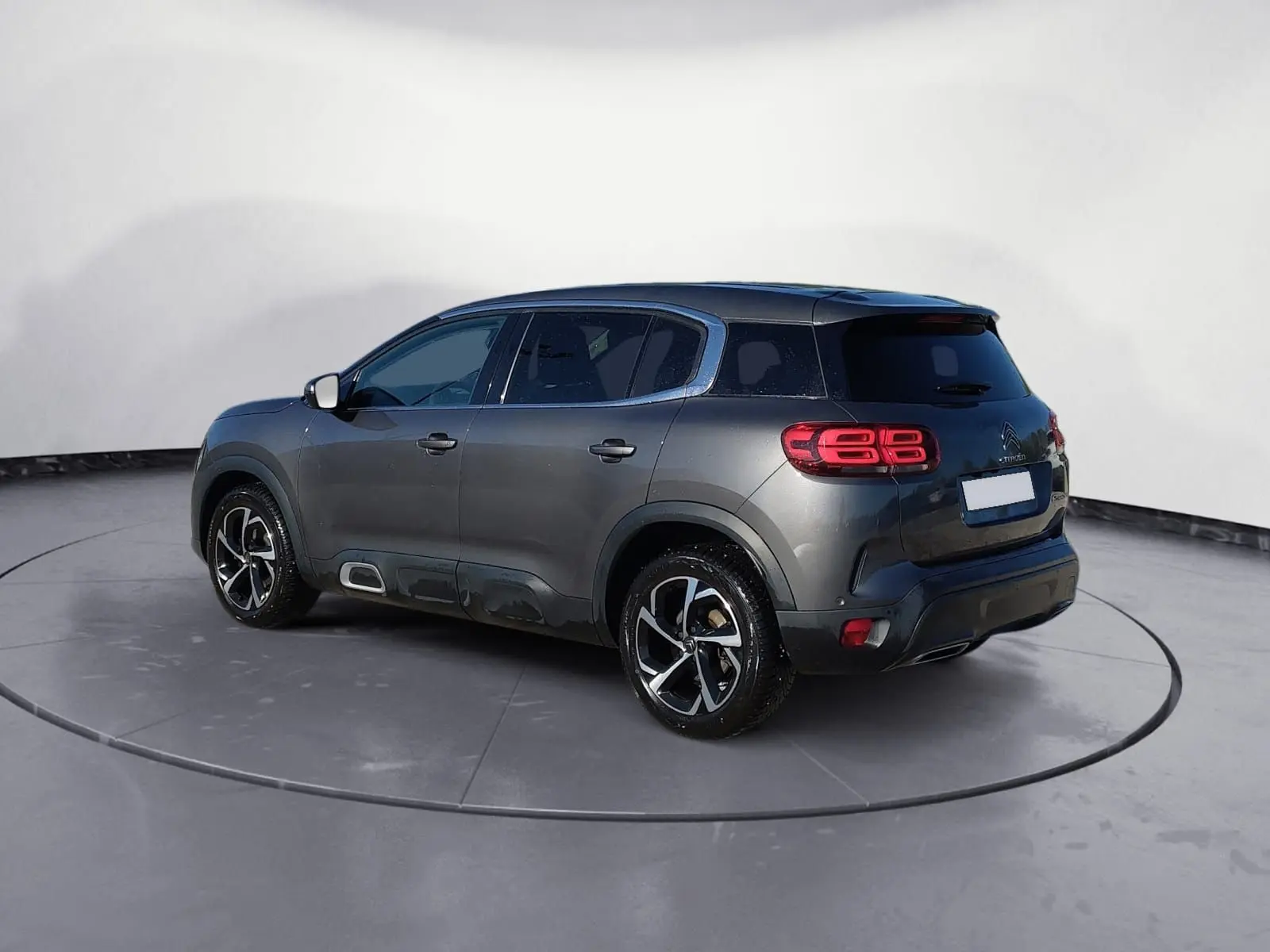 Vue 3/4 arrière droite d'un Citroën C5 Aircross gris platinium avec jantes biton et feux arrière LED distinctifs.