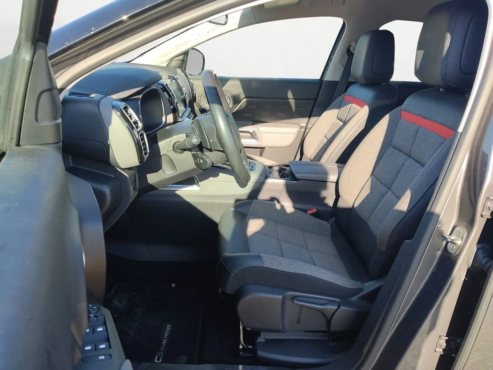 Vue intérieure côté conducteur du Citroën C5 Aircross gris platinium, sièges bi-matière avec bande rouge distinctive.
