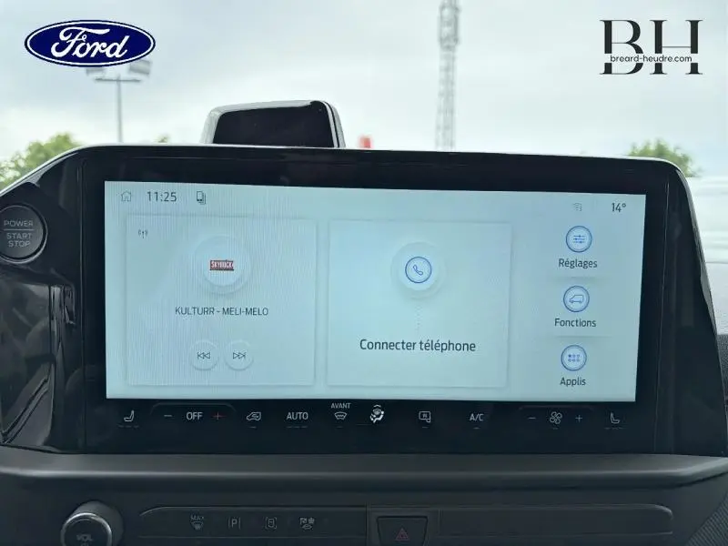 Vue rapprochée de l'écran tactile central du Ford Transit Custom gris, affichant les réglages multimédia et connectivité téléphone.