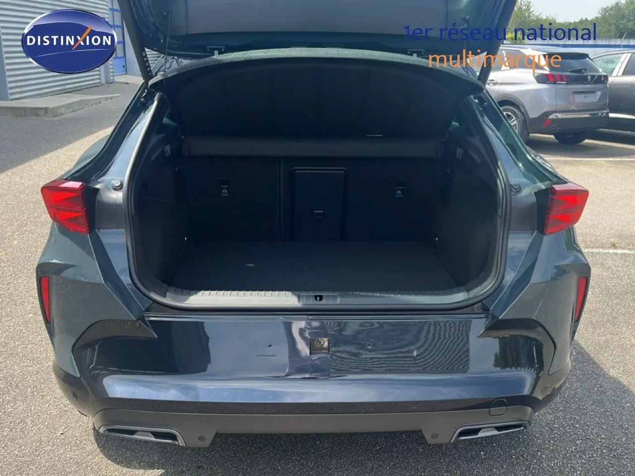 Vue arrière ouverte du coffre d'un CUPRA Formentor bleu Fjord Metal, soulignant son espace de chargement généreux.