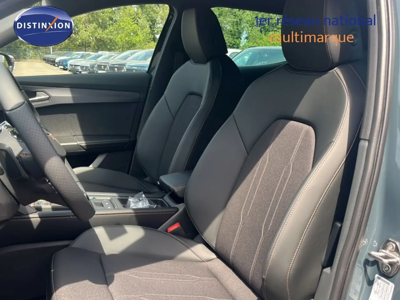Vue intérieure côté conducteur de la CUPRA Formentor bleu Fjord, sièges en cuir et tissu noir avec surpiqûres contrastées.