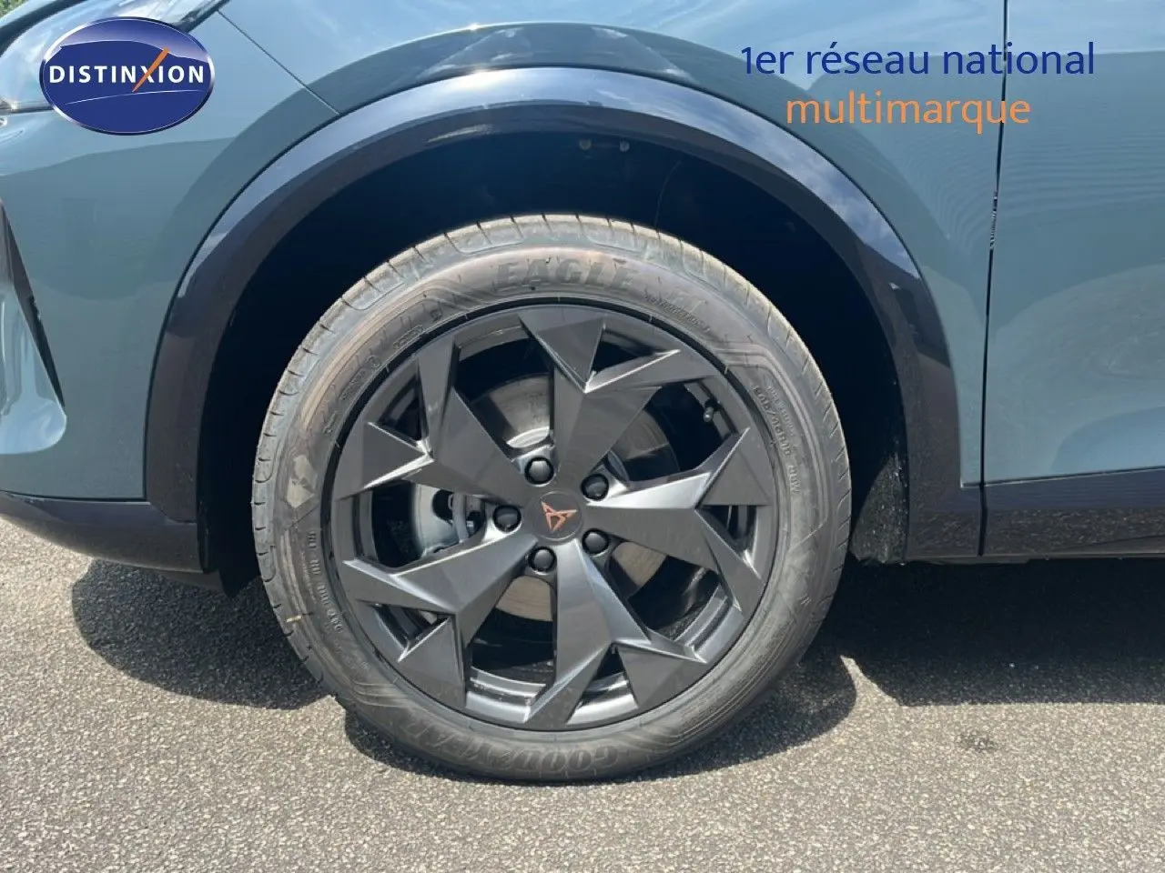 Gros plan sur la roue avant gauche du CUPRA Formentor bleu Fjord Metal avec jante noire au design géométrique.