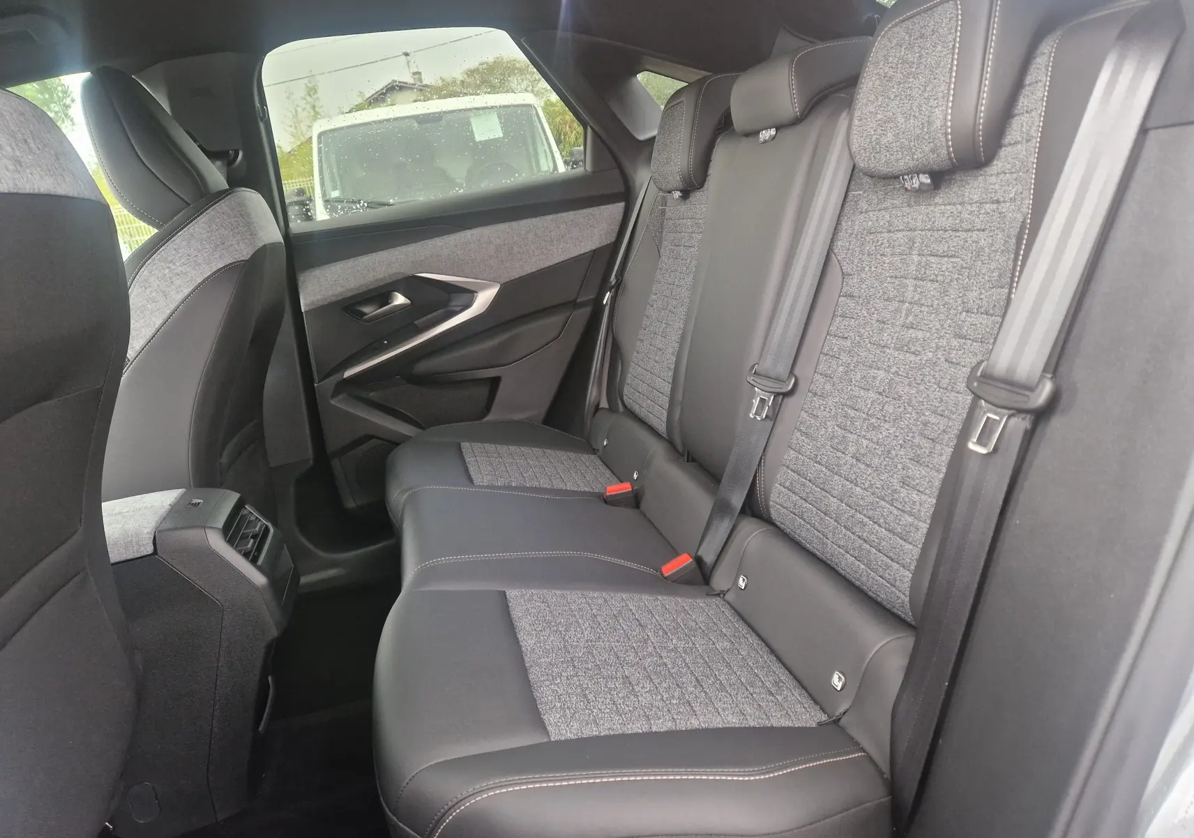 Vue latérale intérieure des sièges arrière du Peugeot 3008 2025 gris Artense, avec sellerie mixte tissu et cuir.