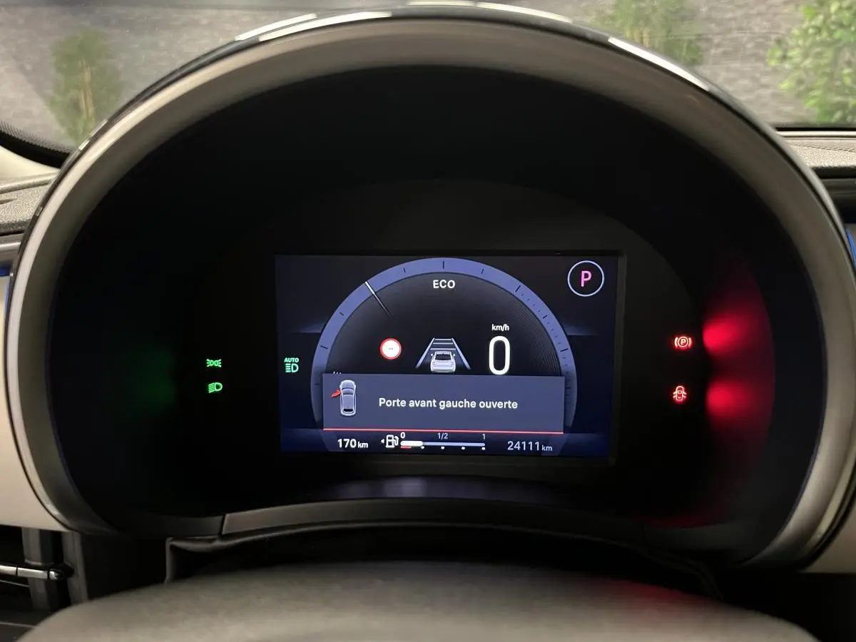 Vue rapprochée du combiné numérique 7 pouces du tableau de bord ivoire du Fiat 600 noir, affichant porte avant gauche ouverte.