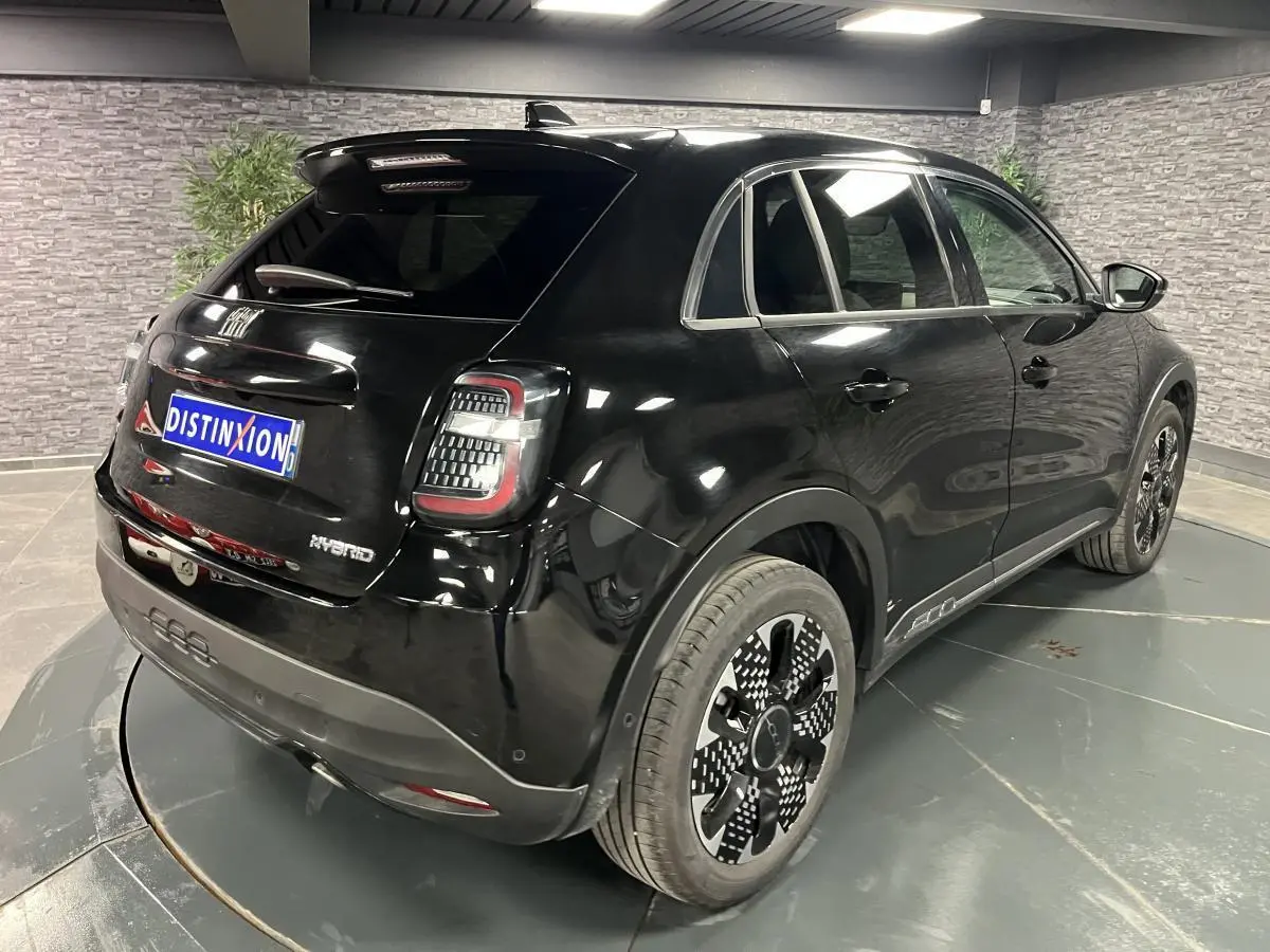 Vue 3/4 arrière droite de la FIAT 600 noire hybride 2024 avec jantes alliage et feux arrière LED distinctifs.