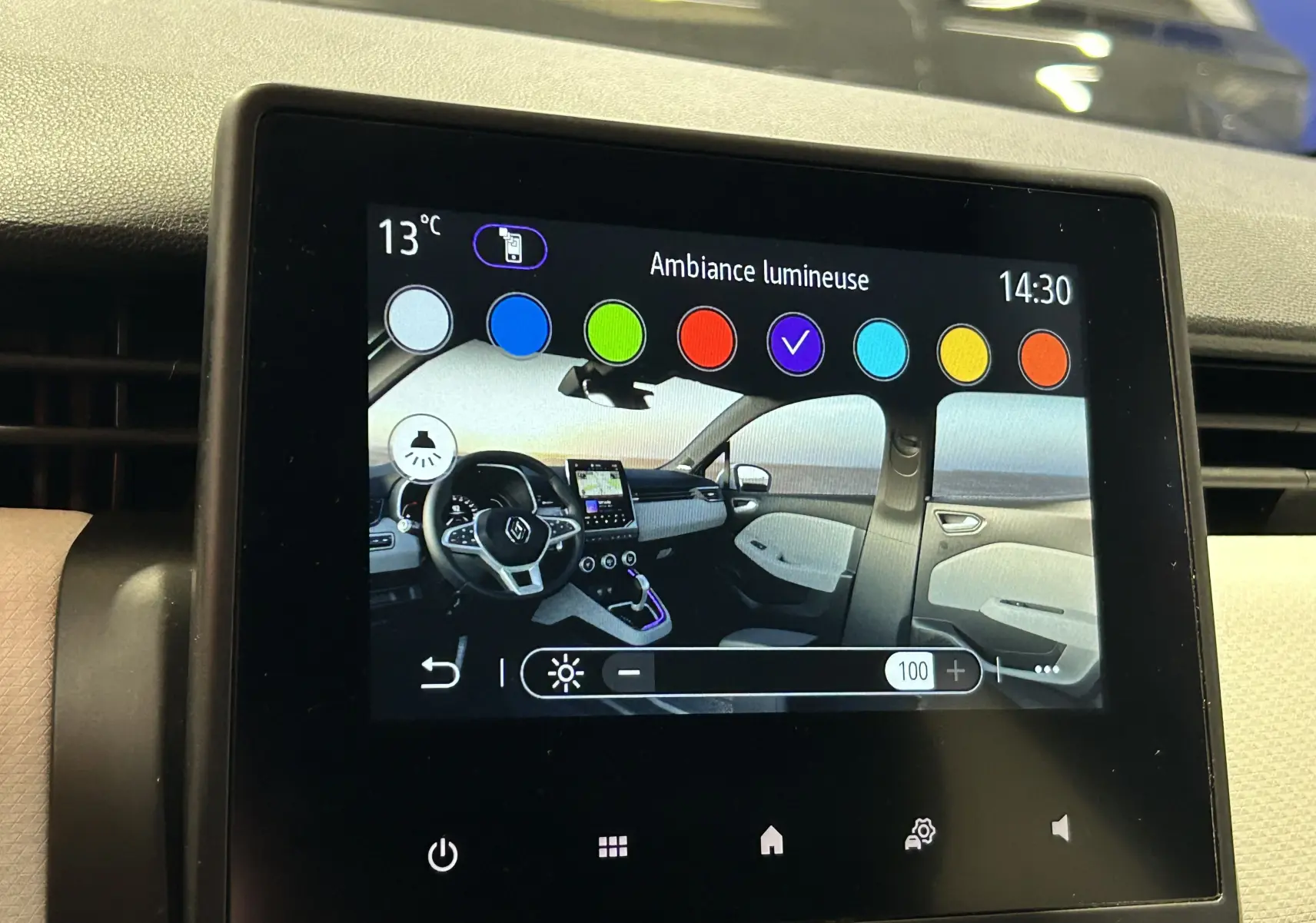 Écran tactile affichant l'ambiance lumineuse intérieure avec vue 3/4 avant du tableau de bord de la Renault Clio V rouge.