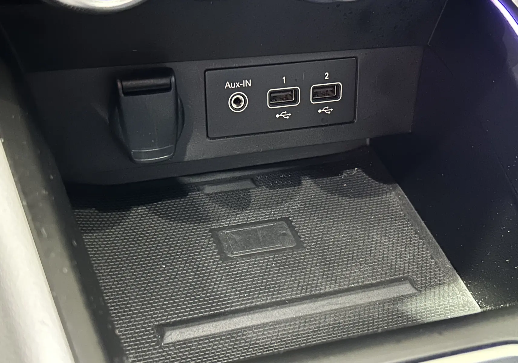 Gros plan sur la console centrale de la Renault Clio V rouge 2023, montrant les ports USB et prise Aux-IN.