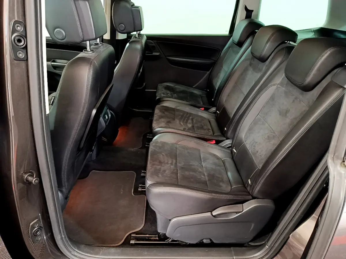 Vue latérale intérieure sur la deuxième rangée de sièges noirs en cuir et alcantara du Volkswagen Sharan marron 2017.