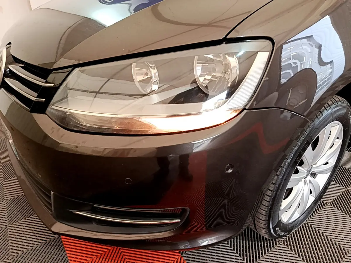 Gros plan sur l'avant droit marron du Volkswagen Sharan 2017, mettant en valeur le phare et la roue.