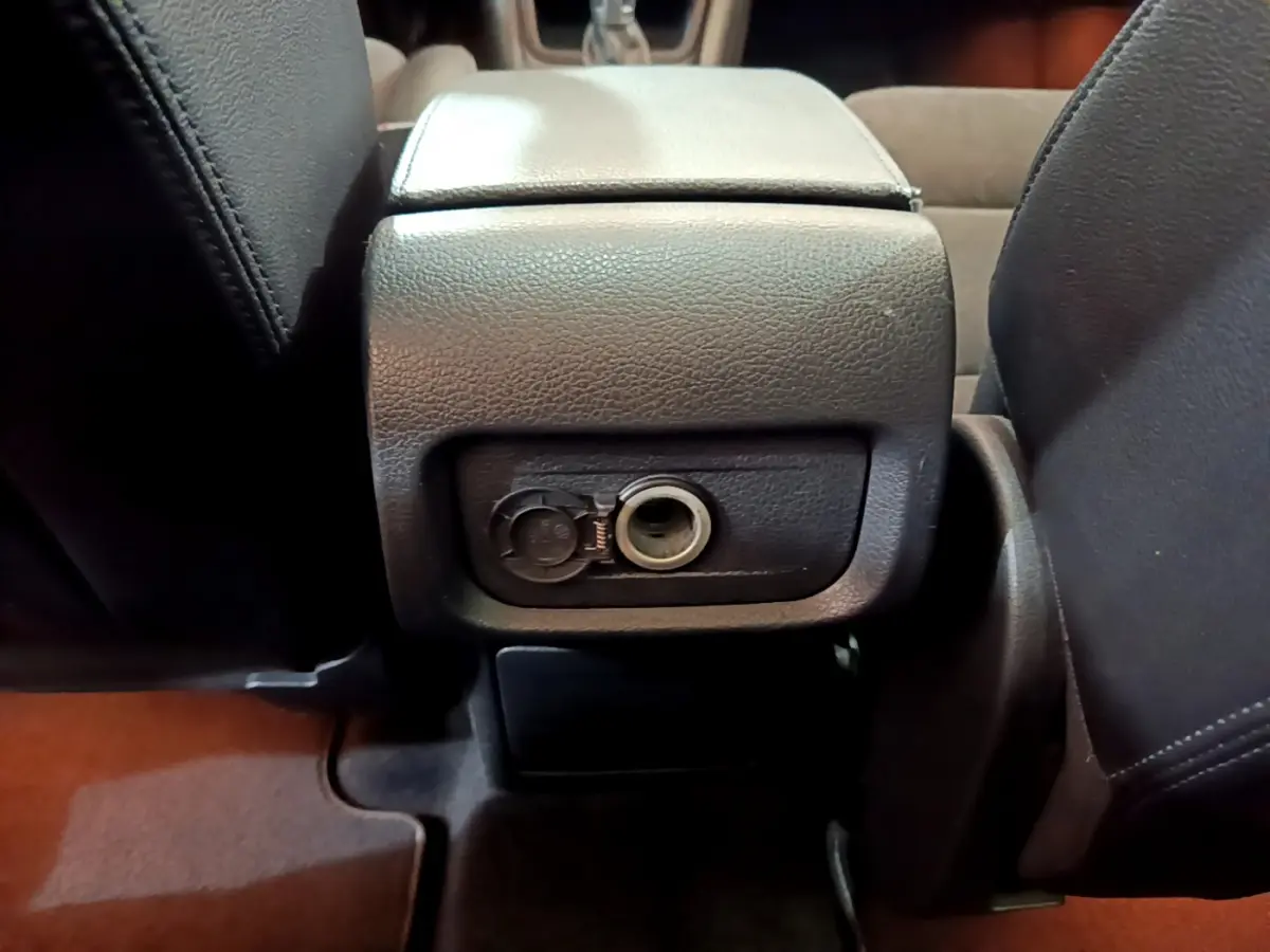 Prise 12V ouverte sous l'accoudoir central entre les sièges avant du Volkswagen Sharan marron 2017