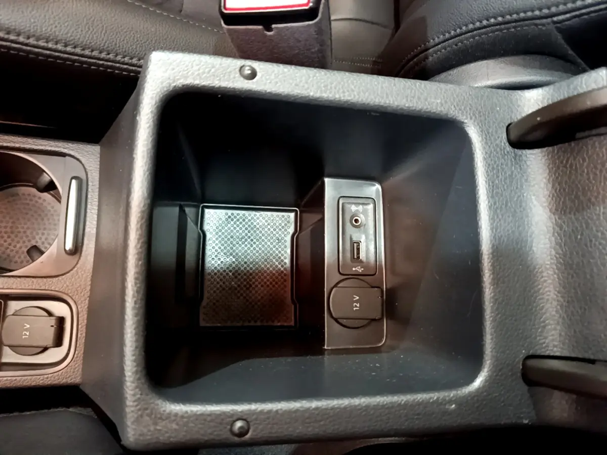 Vue rapprochée de la console centrale noire du Volkswagen Sharan 2017 montrant prises USB, jack audio et prise 12V.