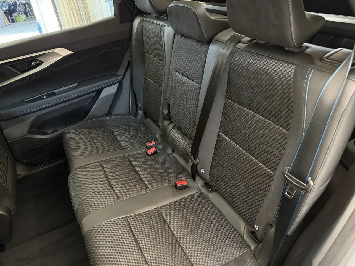 Vue intérieure côté droit sur la banquette arrière noire texturée avec surpiqûres bleues du Renault Espace esprit Alpine 2025.