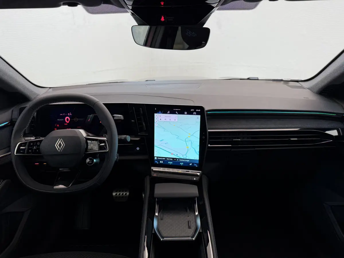 Intérieur avant du Renault Espace gris foncé 2025, tableau de bord moderne avec écran tactile vertical et volant multifonctions.