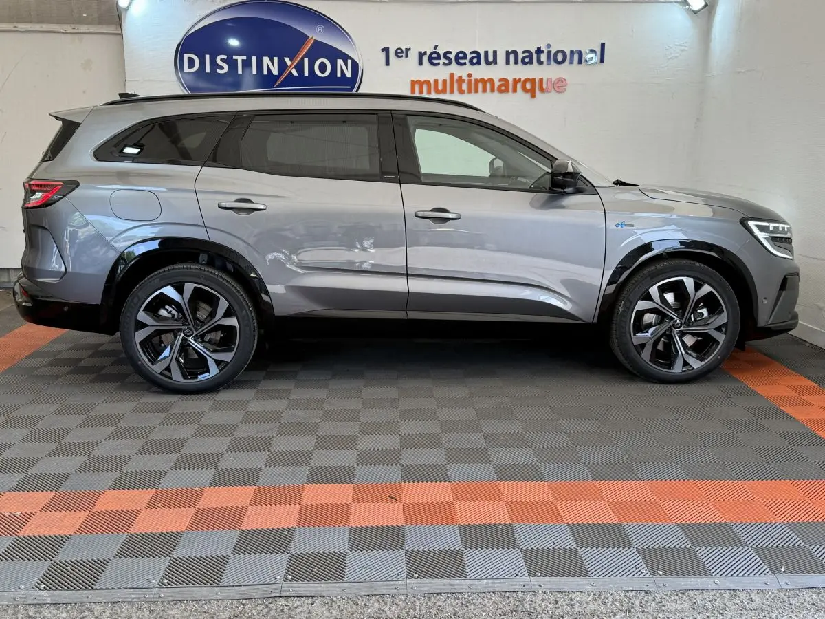 Profil côté gauche du Renault Espace esprit Alpine gris foncé 2025 avec jantes noires et toit noir en intérieur showroom.