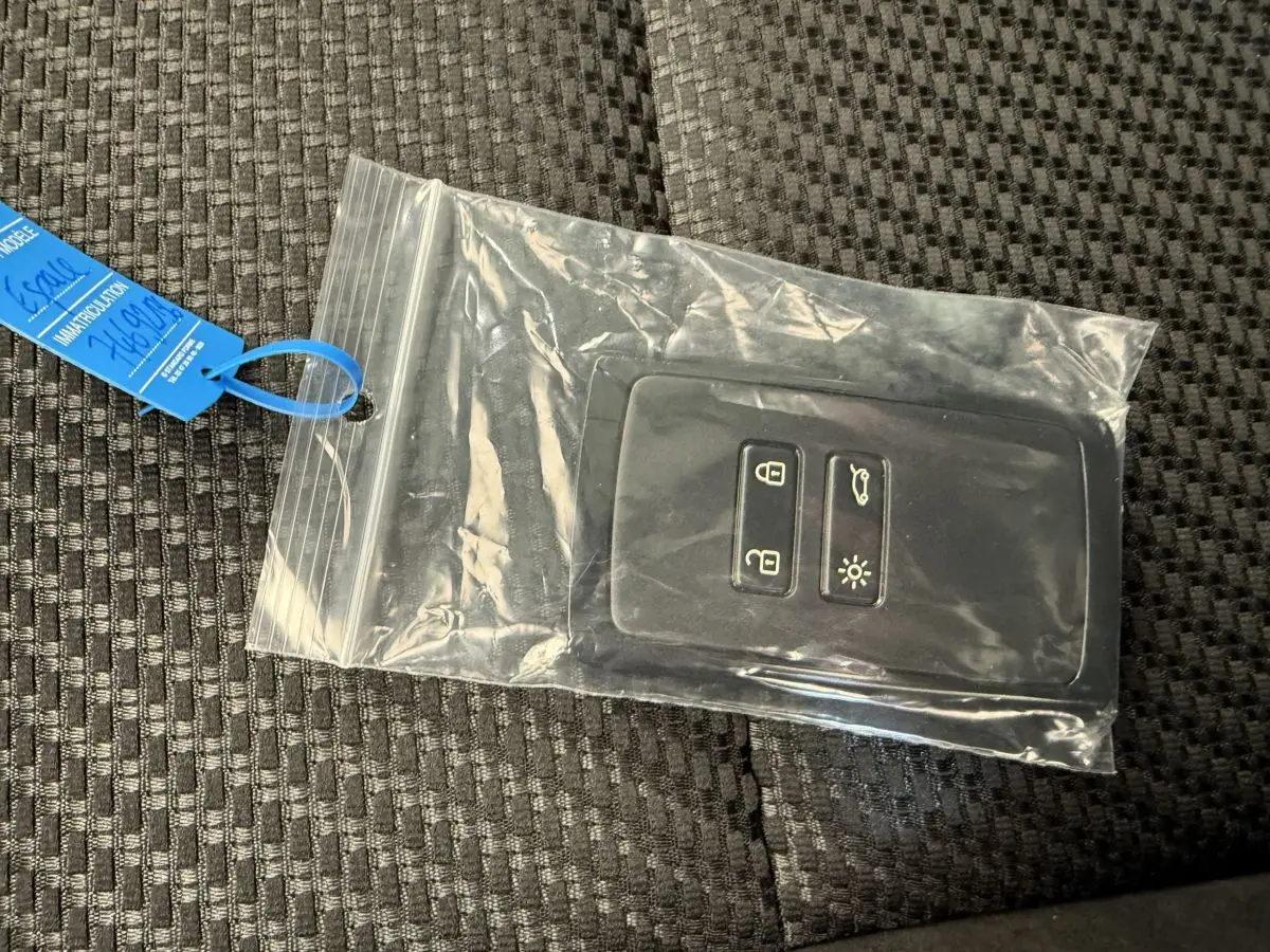 Télécommande noire Renault Espace esprit Alpine 2025 dans sachet plastique sur siège tissu gris foncé