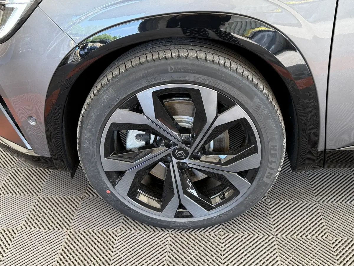 Gros plan sur la roue avant droite du Renault Espace gris foncé, jante alliage noire et grise au design moderne.