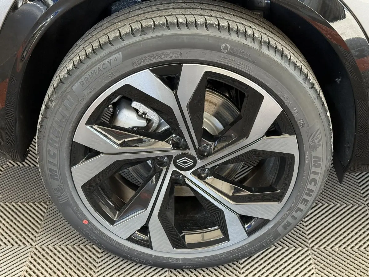 Gros plan sur la jante noire et argentée du côté gauche d’un Renault Espace gris foncé hybride 2025.