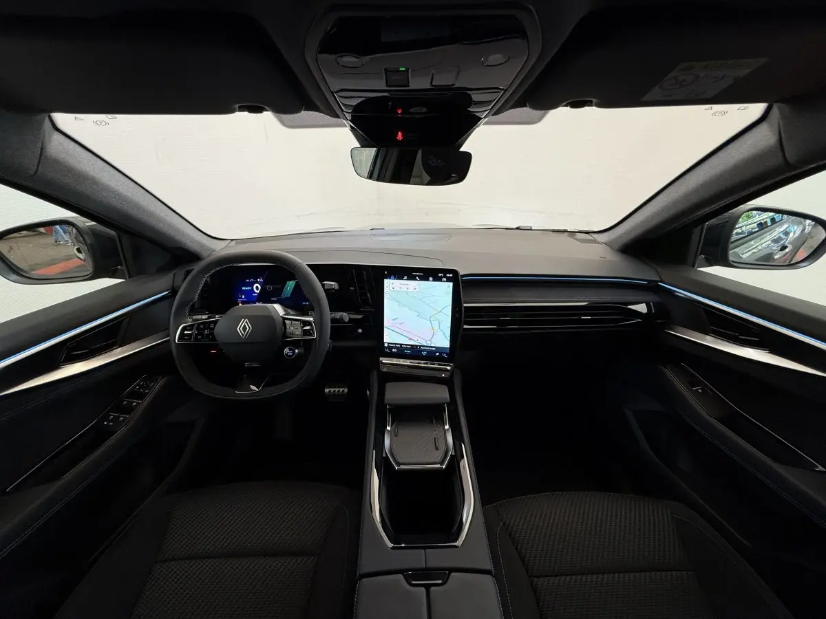 Intérieur Renault Espace esprit Alpine 2025, vue frontale du tableau de bord avec écran tactile vertical et éclairage d'ambiance bleu.