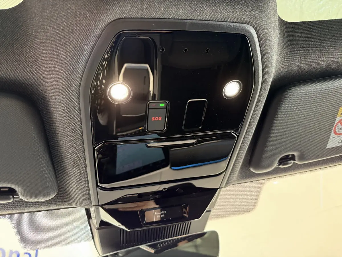 Vue en contre-plongée du plafonnier noir brillant avec bouton SOS et éclairages dans un Renault Espace gris foncé 2025 esprit Alpine.